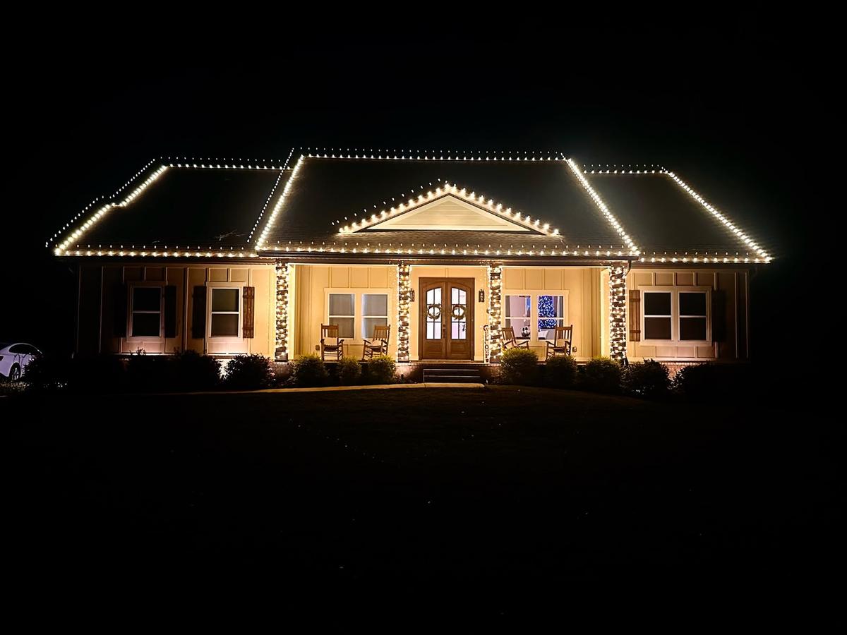 Ranch home outlined in warm white roofline lights