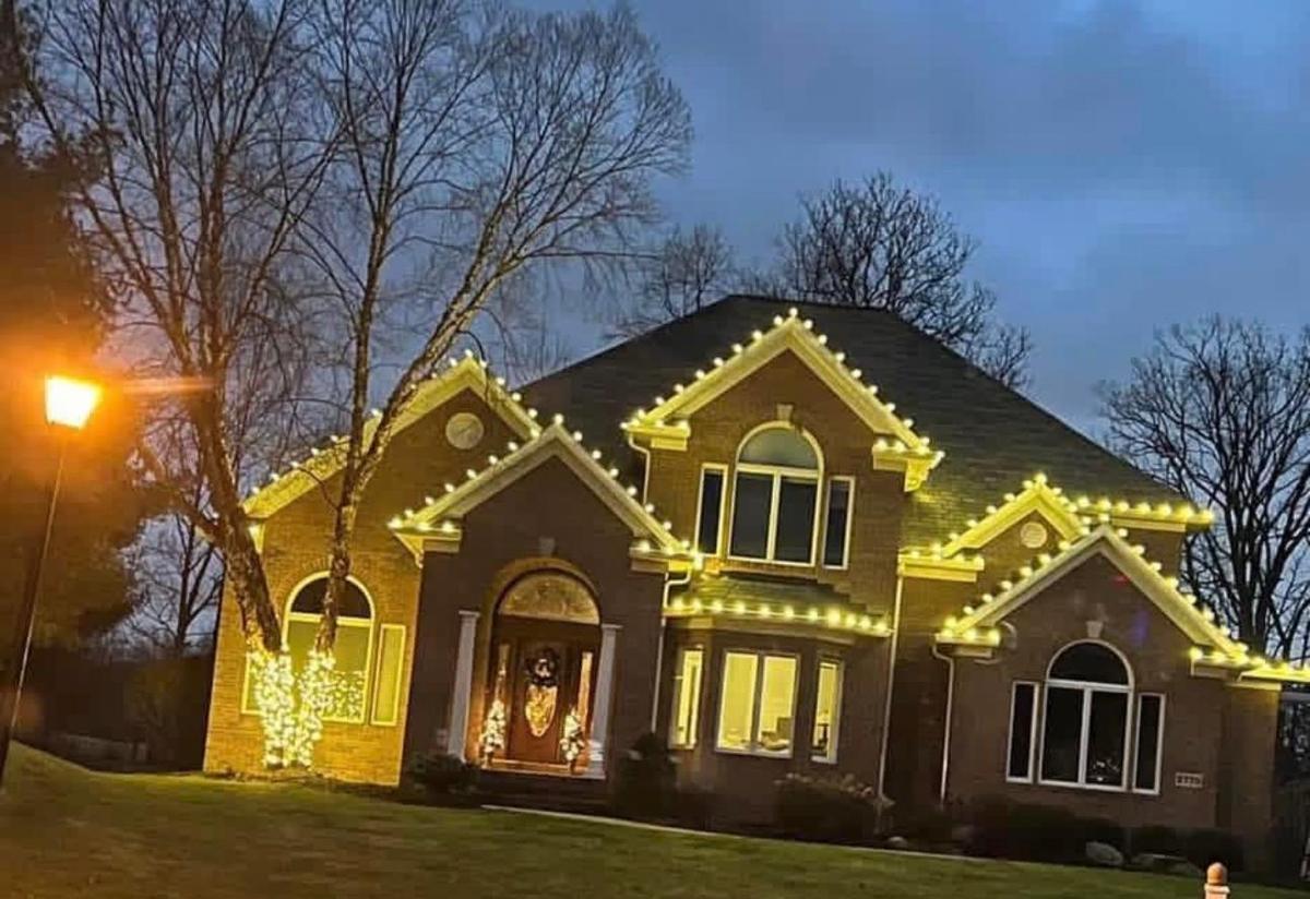 Brick home with warm white roofline lights at dusk