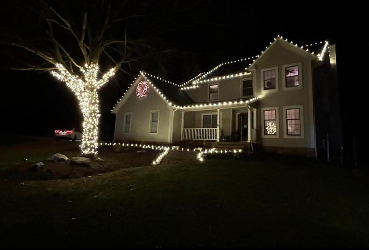 Home with warm white roofline and a wrapped tree