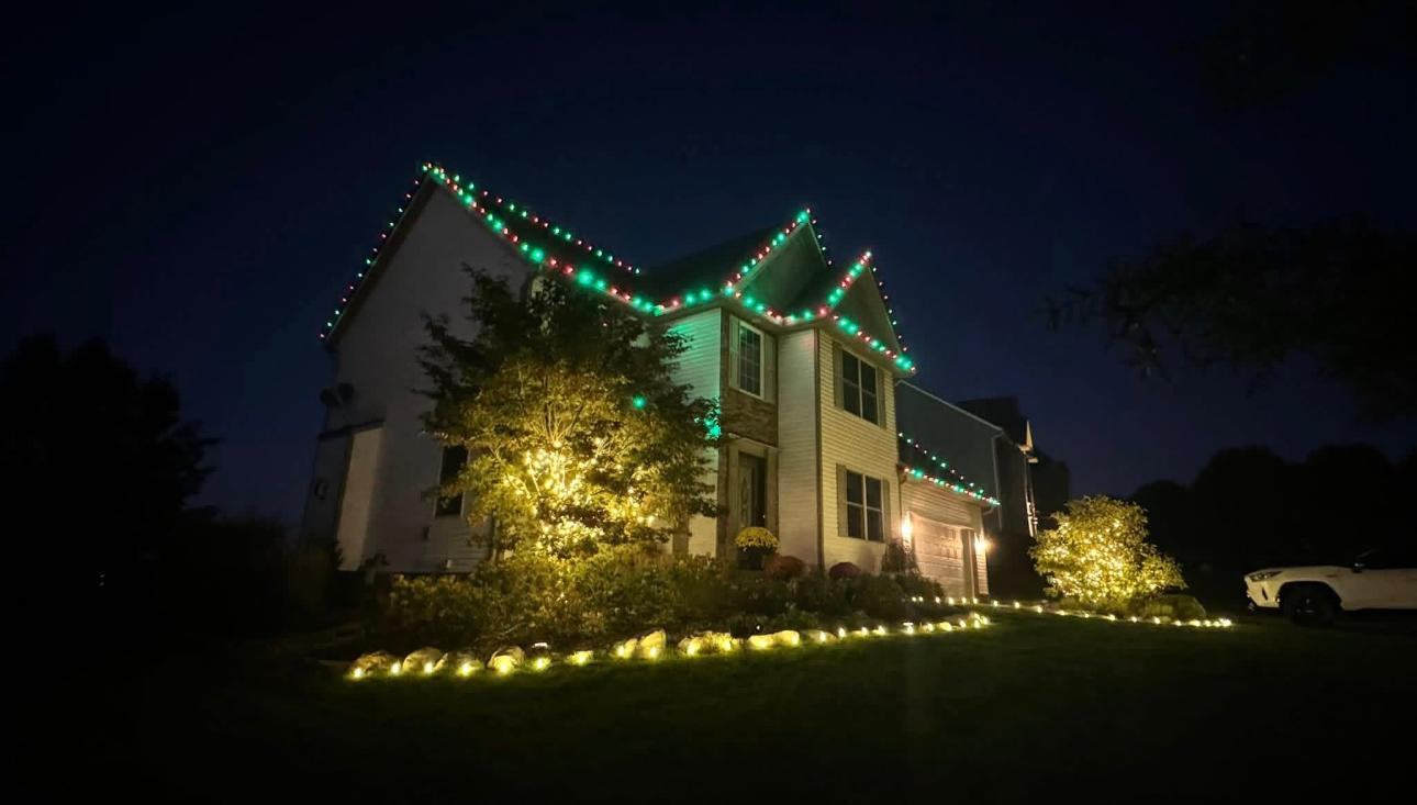 Red and green roofline with warm white landscape and pathway lighting